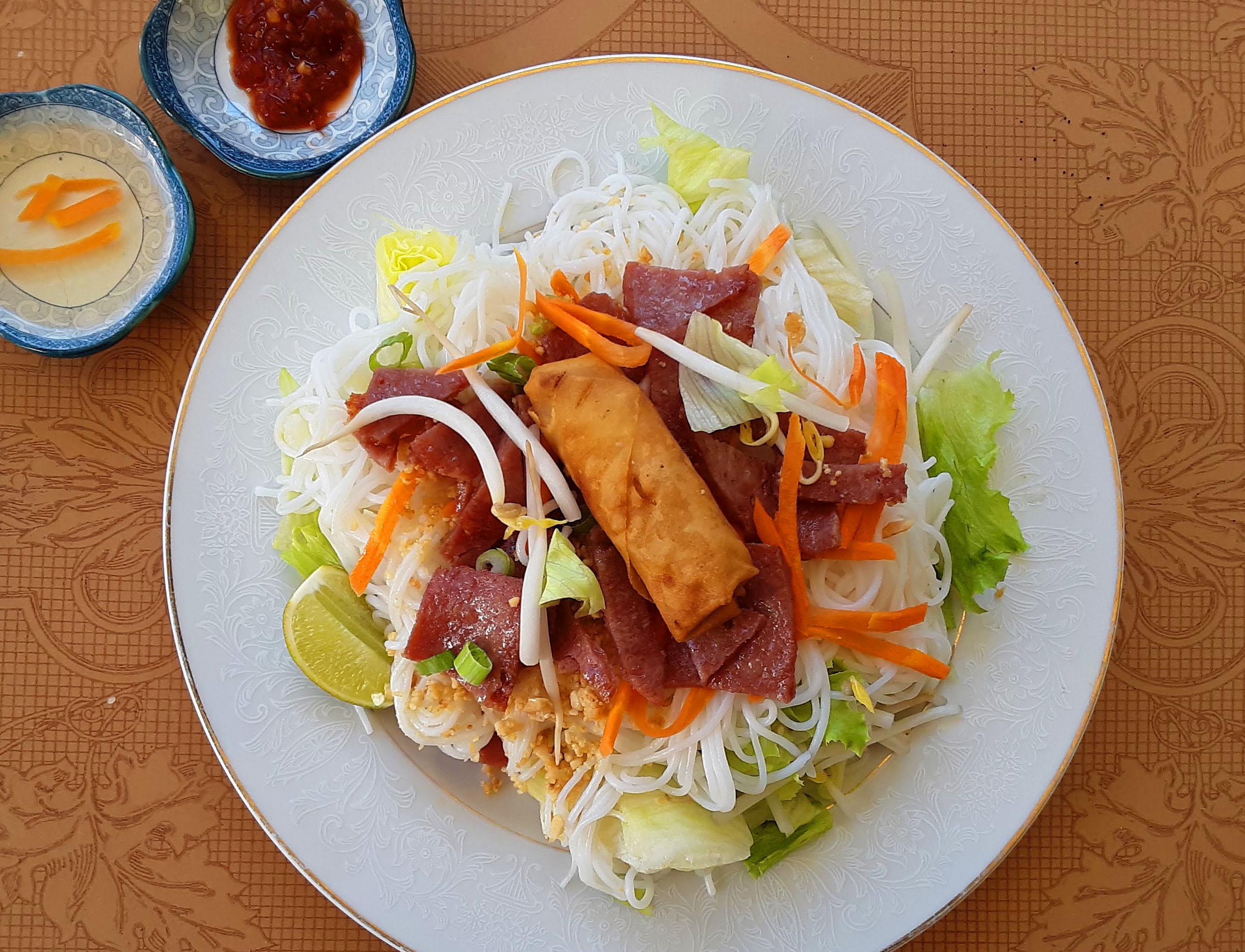 On a white plate, there is a bun nem nuong salad. Photo by Paul Young.