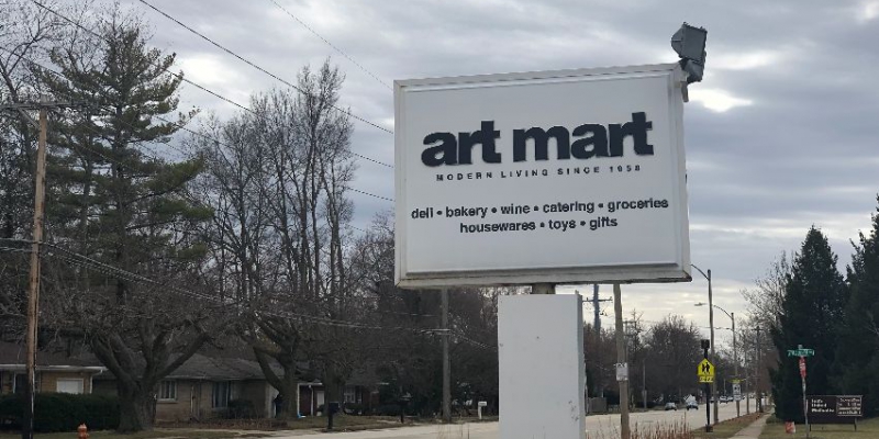 Art Mart's signage visible outside of their store, a white sign with black lettering.