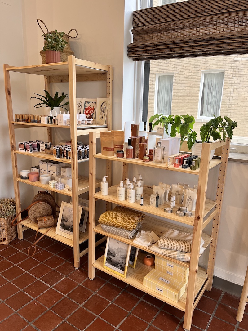 Two wooden shelves with bottles of lotions, oils, sprays, and other body care items. Photo by Dani Nutting. 
