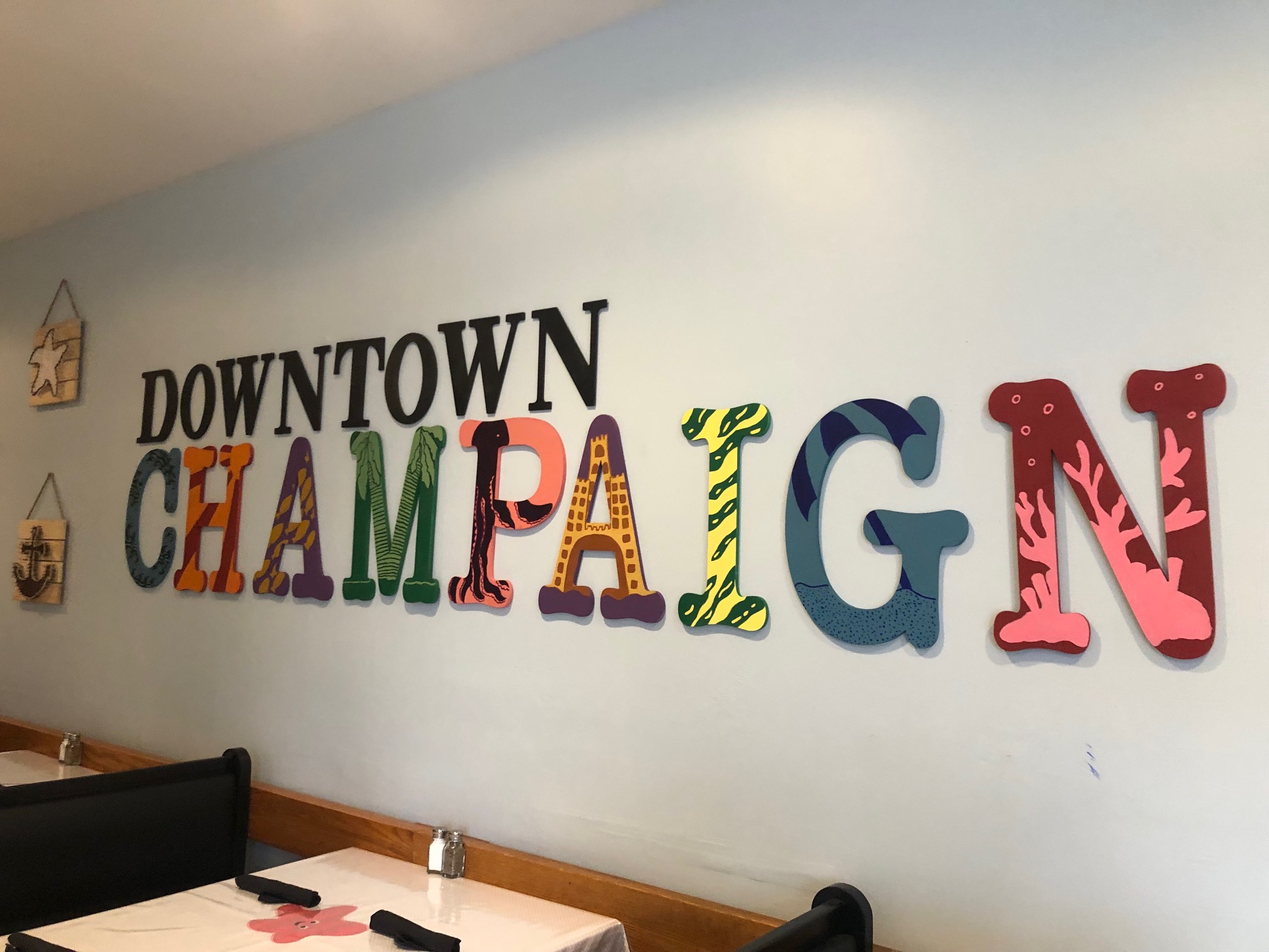 On the wall of La Bahia Grill's dining room, there are letters painted in different colors and animal prints reading DOWNTOWN CHAMPAIGN. Photo by Alyssa Buckley.