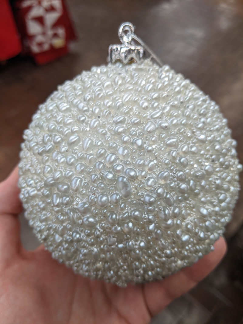 The writer is holiding a large white ornament that looks like it has bubbles all over it. Photo by Tom Ackerman.