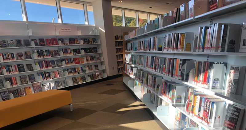 Photo of inside the Champaign Public Library featuring shelves of books and seating areas. Photo from the CPL Facebook page.