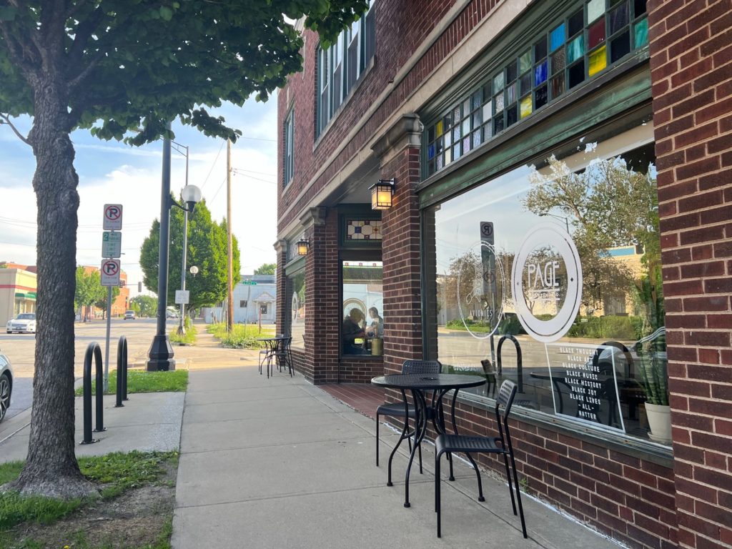 The exterior of Midtown Champaign's Avionics Flying Machine Coffee, shared space with Page Roasting Company, a brick building with stained glass tiles above big windows.