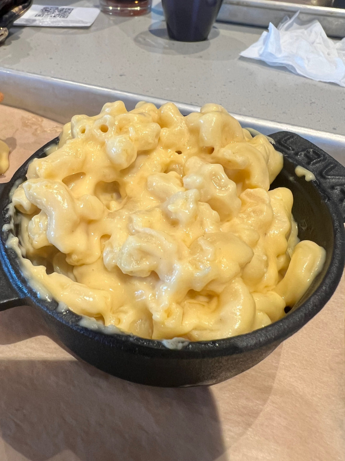 A black cup of macaroni and cheese.