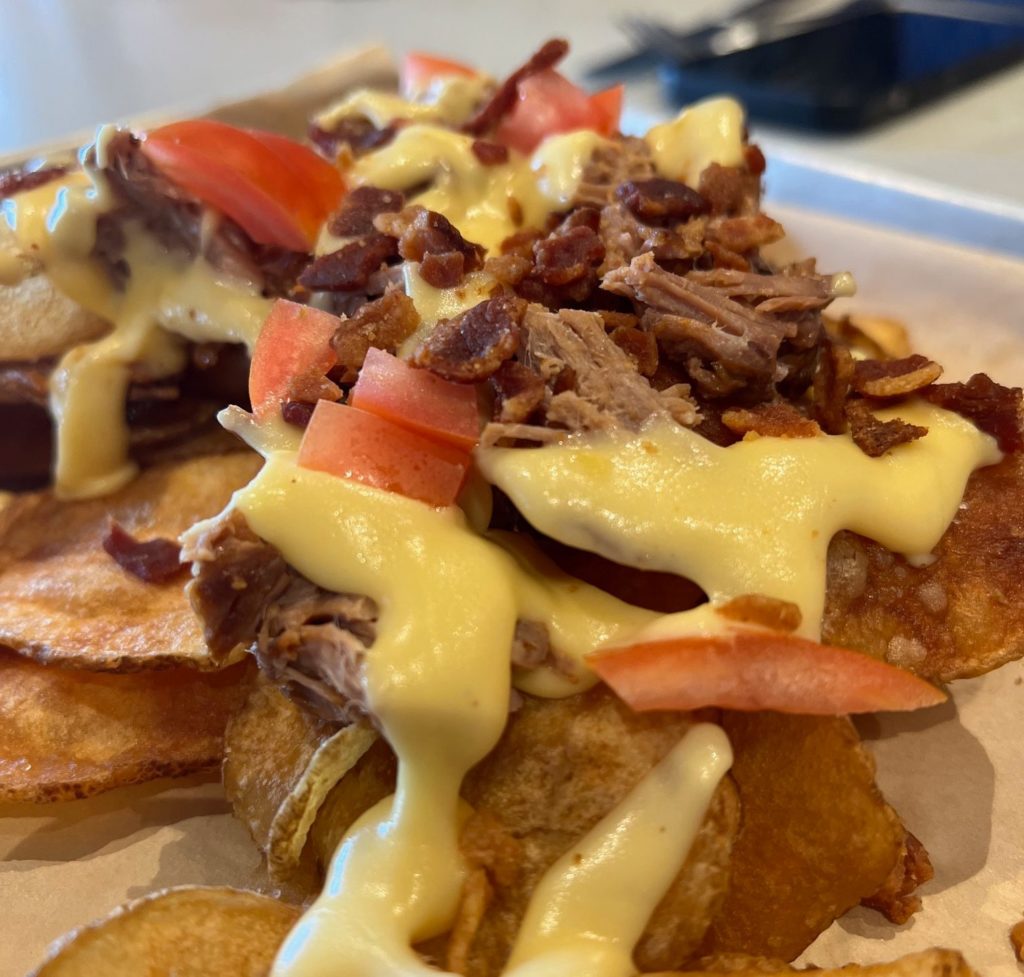 Pork nachos with bacon and cheese sauce.